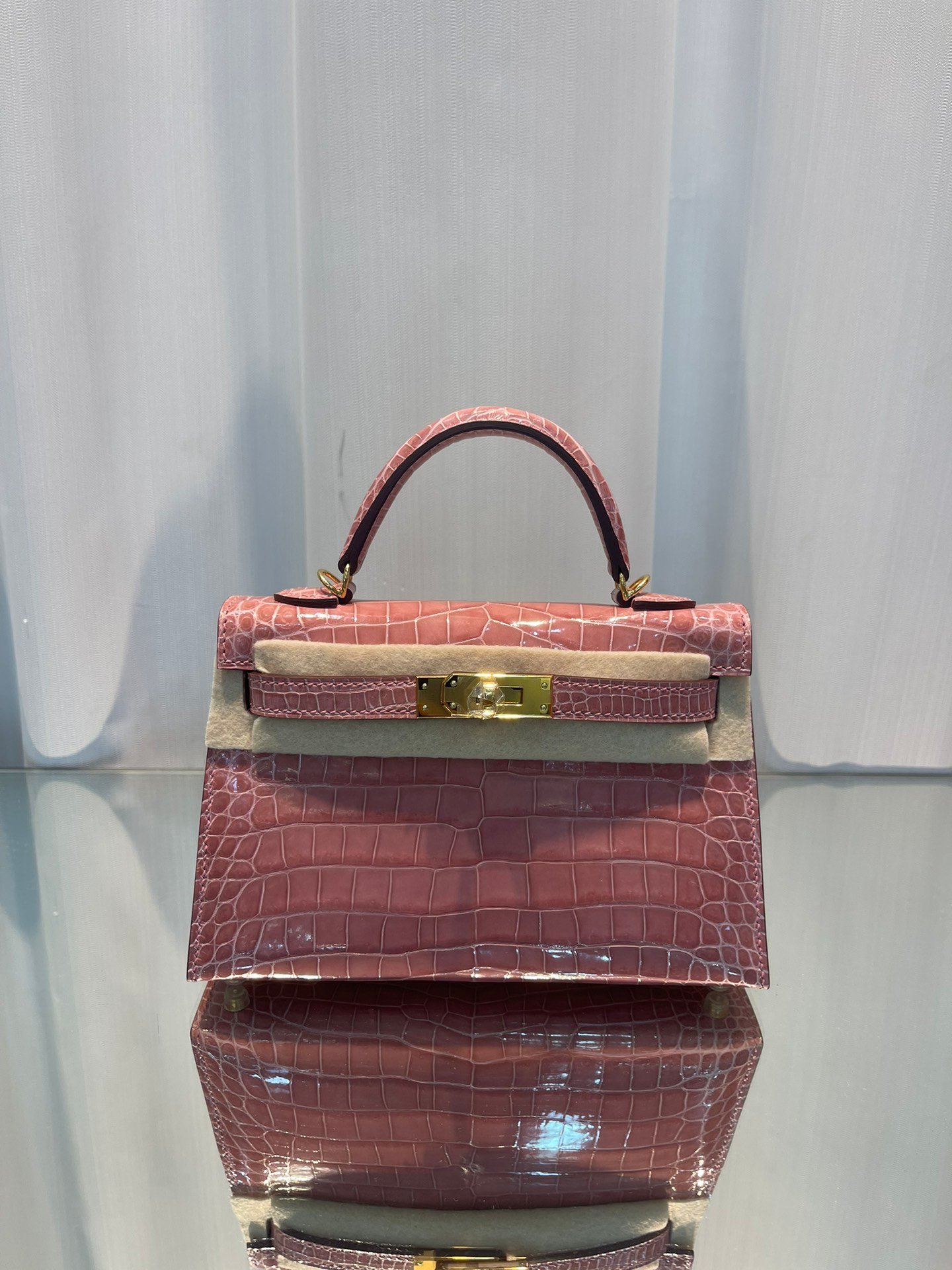 Minikelly II
Candy pink/gold buckle
High gloss crocodile leather, hand-sewn with top wax thread, sheepskin lining